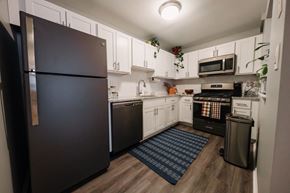 Branchburg apartment for rent - a kitchen with white cabinets and black appliances and a black refrigerator