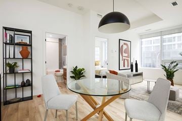 Montreal apartment for rent - A modern dining room with a glass table and grey chairs.