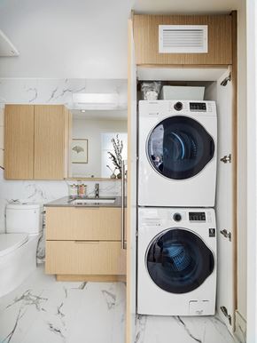 Vancouver apartment for rent - A washing machine is in a cabinet in a kitchen.