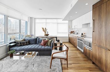 Vancouver apartment for rent - A modern living room with a grey sofa and a wooden chair.
