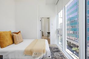Montreal apartment for rent - A bedroom with a bed, pillows, and a blanket.