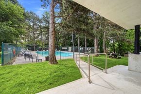 Burlington apartment for rent - A pool surrounded by trees and a fence.