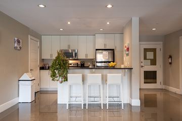 Bedford apartment for rent - A kitchen with white chairs and a counter.