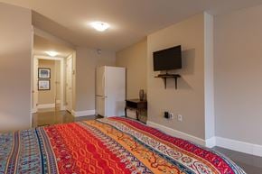 Bedford apartment for rent - a bedroom with a bed and a refrigerator and a television