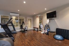 Bedford apartment for rent - a gym with exercise equipment and a tv on the wall