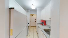 Toronto apartment for rent - A kitchen with white cabinets and a red appliance.