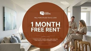 Toronto apartment for rent - A man and woman are sitting on a couch in a living room, with a large orange circle in the foreground advertising a 1 month free rent offer.