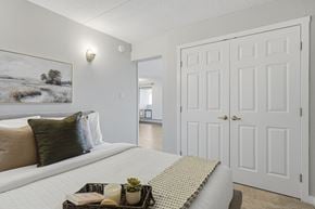 Edmonton apartment for rent - A bedroom with a large bed and a painting on the wall.