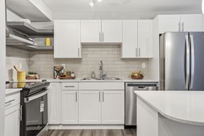 Edmonton apartment for rent - A modern kitchen with white cabinets and stainless steel appliances.