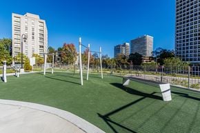 Toronto apartment for rent - A park with a green lawn and a white bench.
