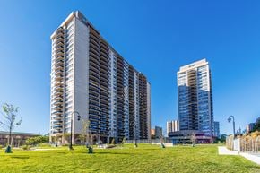 Toronto apartment for rent - Two tall buildings with balconies are surrounded by a grassy area.