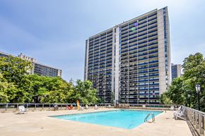 Toronto apartment for rent - A large building with a pool in front of it.
