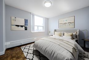 Toronto apartment for rent - A bedroom with a large bed and two pieces of artwork on the wall.