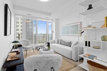 Ottawa apartment for rent - A living room with a white couch and a large window.