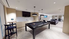Toronto apartment for rent - A pool table is in the middle of a room with a bar and a television.