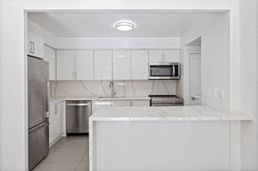 Toronto apartment for rent - a white kitchen with a counter top and a refrigerator at 50 Prince Arthur