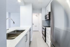 Toronto apartment for rent - A modern kitchen with white cabinets and stainless steel appliances.