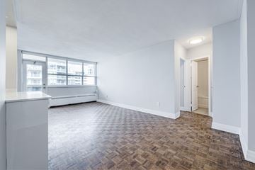 Toronto apartment for rent - A room with a brown floor and white walls.