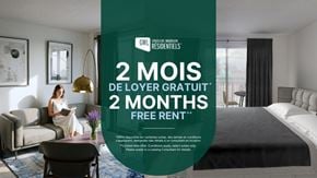 Montreal apartment for rent - A woman is sitting on a couch in a room with a large bed and a desk.