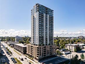 Ottawa apartment for rent - A tall building with many windows stands in the middle of a city street.