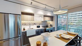 Toronto apartment for rent - A modern kitchen with a stainless steel refrigerator and a dining table set with plates and utensils.