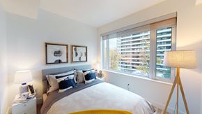 Toronto apartment for rent - A bedroom with a large bed, two lamps, and pictures on the wall.