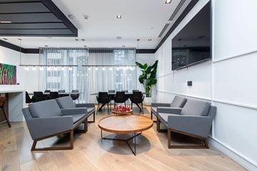 Montreal apartment for rent - A modern living room with grey sofas and a wooden coffee table.