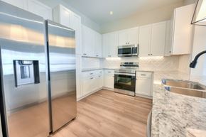 Columbus apartment for rent - A modern kitchen with a stainless steel refrigerator and wooden flooring.