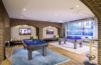 A games room with two pool tables and a television