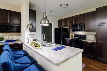 A kitchen with dark wood cabinets and a white counter top