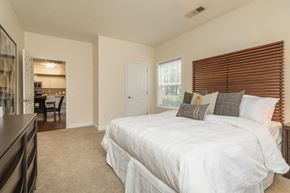 Mansfield apartment for rent - A bedroom with a large bed and a window with blinds.