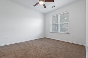 Savannah apartment for rent - A room with a ceiling fan and a window with a view of trees.