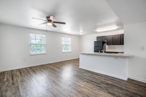 Columbia apartment for rent - A spacious room with a ceiling fan and wooden flooring.