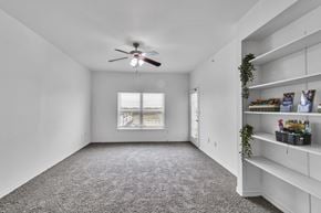 Ft Worth apartment for rent - A room with a ceiling fan and a window with blinds.