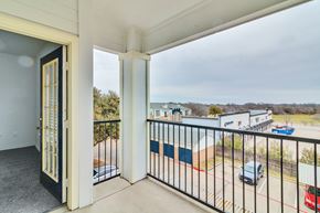 Ft Worth apartment for rent - A balcony with a view of a parking lot and buildings.