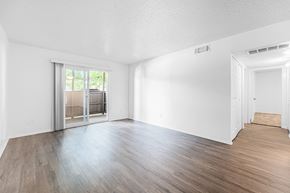 Ft. Worth apartment for rent - A room with wooden floors and white walls, featuring a sliding glass door.
