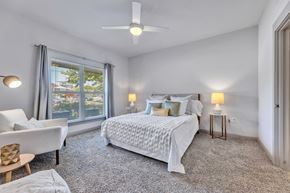 Round Rock apartment for rent - a bedroom with a bed and a large window