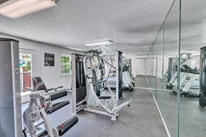 Irving apartment for rent - a gym with weights and mirrors on the floor and a glass wall