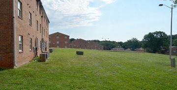 Lynchburg apartment for rent - a field of grass next to a brick building