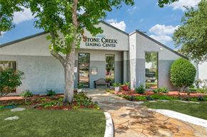 Lewisville apartment for rent - a stone creek leasing center with a tree in front of it