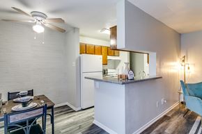 Lewisville apartment for rent - the living room and kitchen of a apartment with a table and chairs and a refrigerator