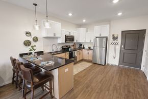 Andover apartment for rent - a kitchen with stainless steel appliances and a island with chairs