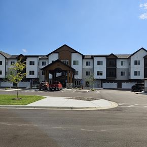Alexandria apartment for rent - A large white building with a brown roof and a parking lot in front.