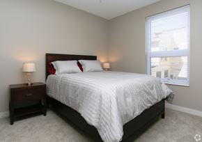 Owatonna apartment for rent - A bedroom with a bed, nightstand, and window.