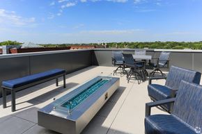 Owatonna apartment for rent - A rooftop patio with a hot tub and chairs.