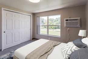 Rochester townhouse for rent - a bedroom with a bed and a window with an air conditioner