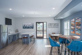 Dodge Center apartment for rent - a dining room and kitchen with a table and chairs and a refrigerator and a door