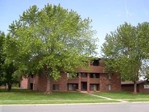St Cloud apartment for rent - A large brick building with a tree in front of it.