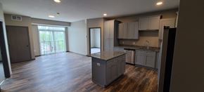 Melrose apartment for rent - an empty kitchen and living room with a door to a balcony