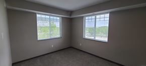 Melrose apartment for rent - a bedroom with two windows and a carpeted floor